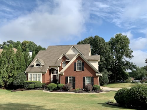 Exterior of a brick colonial residential home with classic gables.
